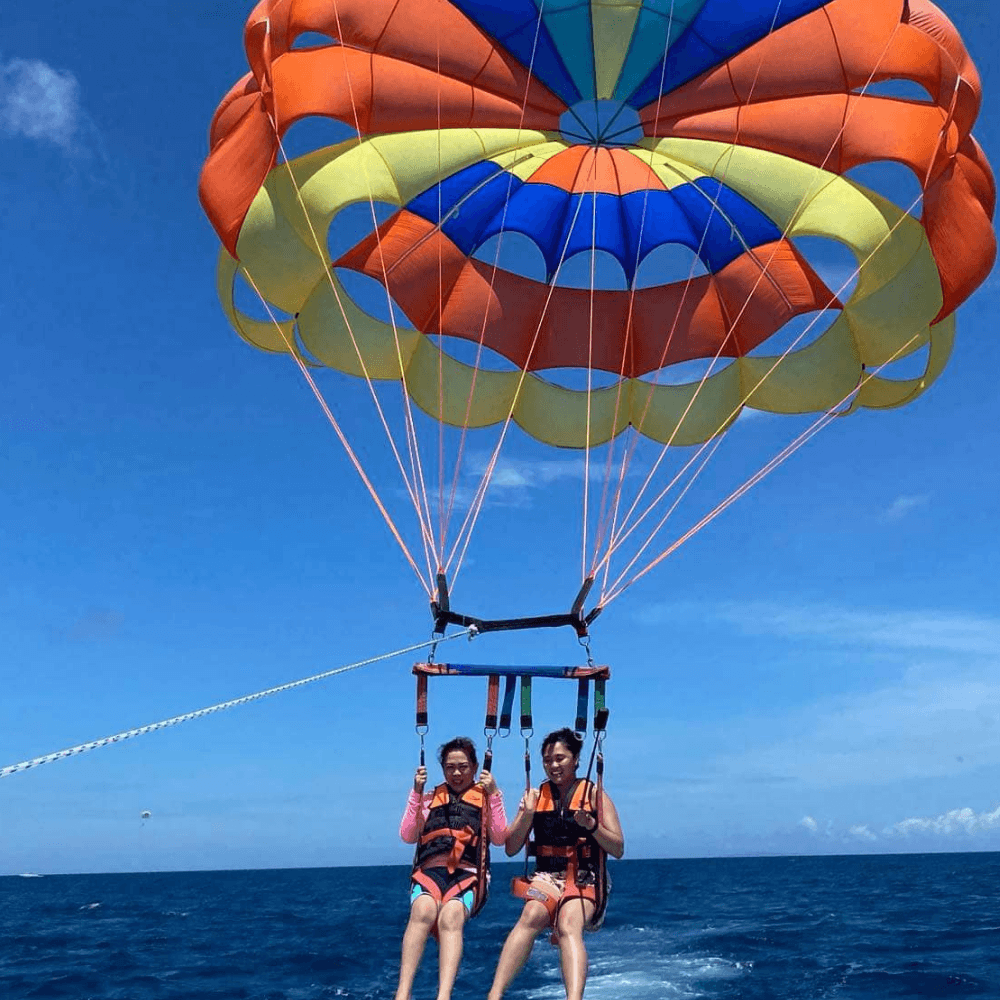 Boracay parasailing adventure with tourists flying over the ocean in Boracay Philippines