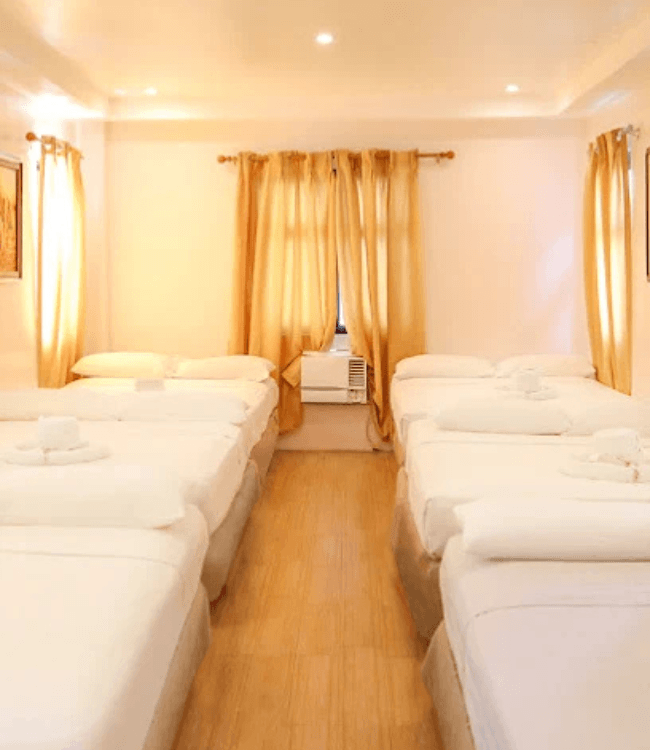 Boracay hotel room with multiple beds and comfortable interior.